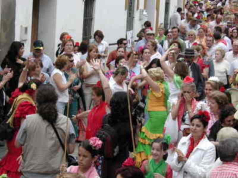 Fiesta de Carnaval en una calle con disfraces y mucha gente celebrando.