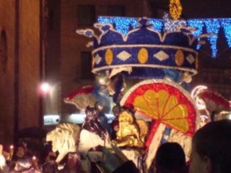 Desfile de carnaval con personajes y decoración navideña.