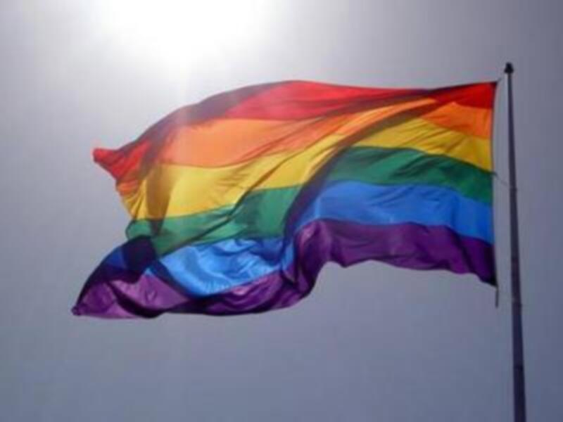 Bandera del arcoíris ondeando al viento, símbolo de la diversidad y la inclusión.