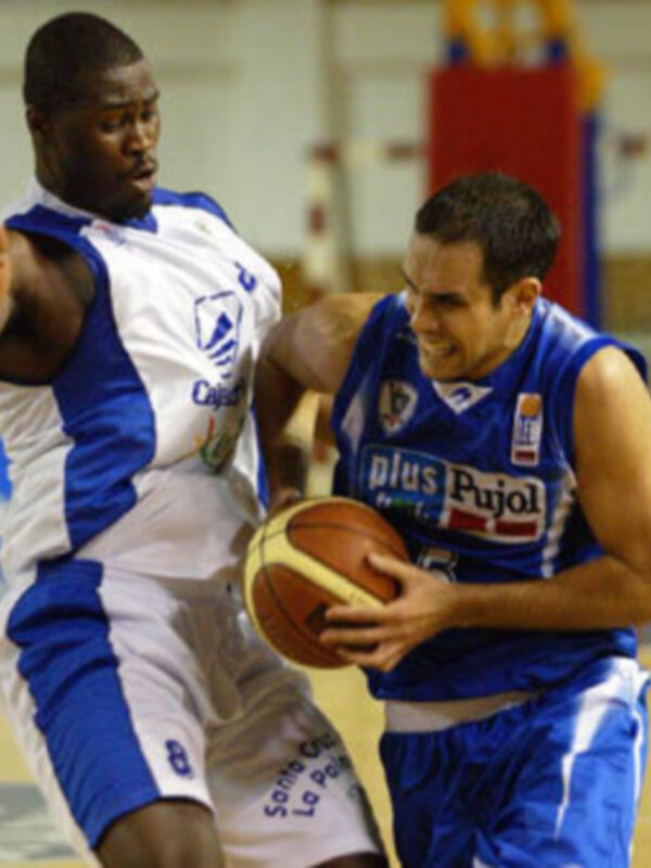 Imaginación: Un jugador de baloncesto en acción, con un fondo de cancha y un árbitro en el fondo.