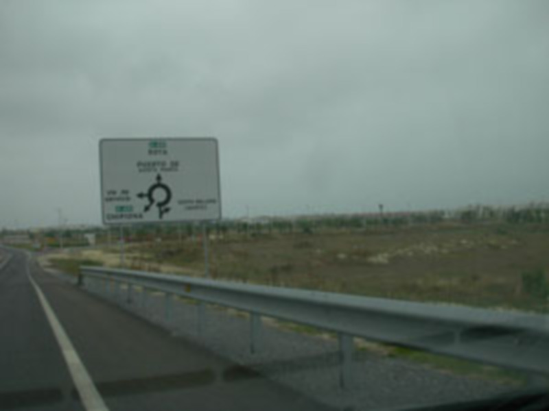 Vista de una carretera con un letrero indicando la dirección hacia la ciudad de Puebla, México, en un día nublado.