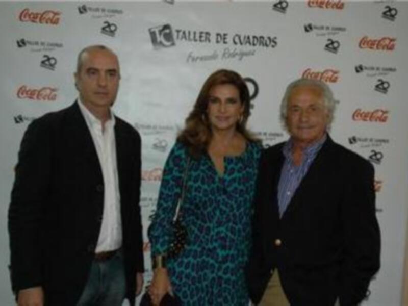 Tres personas posan frente a un fondo con logos de Coca-Cola y el texto "Taller de Cuadros Fernando Belisario".
