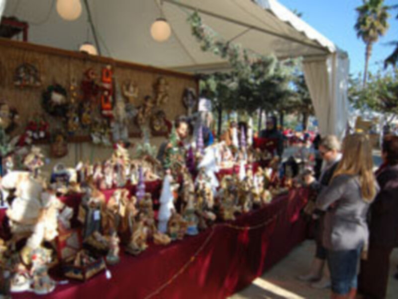Mesa decorada con figuras de porcelana en un mercado al aire libre.