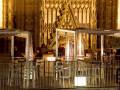 Café al aire libre frente a la catedral gótica de Sevilla, España, iluminado por la noche.