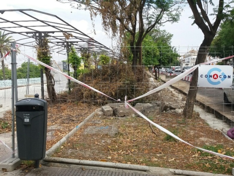 Un paraguas de color púrpura colgando del poste de un poste de luz en la orilla del agua.