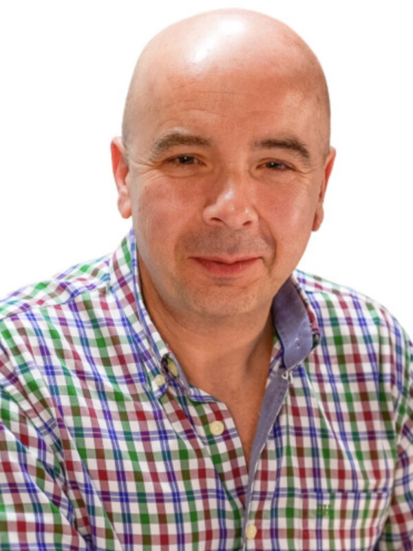 Retrato de hombre con camisa a cuadros multicolor, fondo blanco.