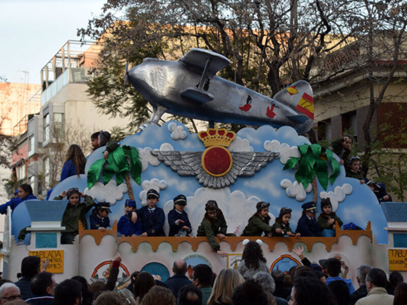Desfile de carros alegóricos con un avión y elementos marítimos.