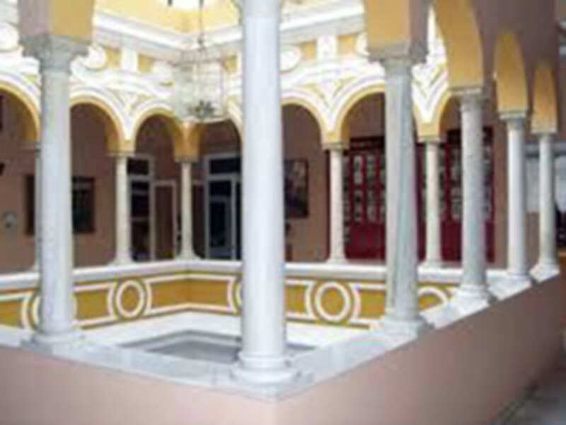 Interior de una casa colonial con arcos y columnas blancas. Paredes pintadas en tonos pastel. Altura de las columnas y arcos proporciona un aspecto clásico y elegante.