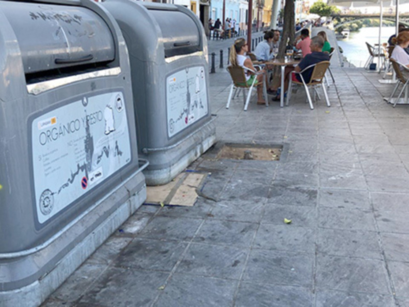 Bodegones de reciclaje con etiquetas informativas y grafitis en el suelo.