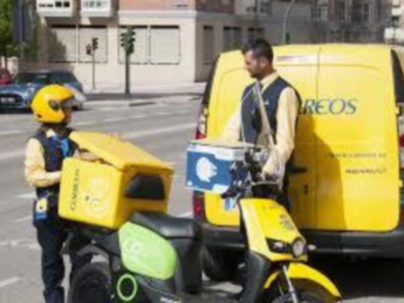 Dos trabajadores de reparto en bicicleta de entrega de paquetes, con vehículos amarillos y azules.