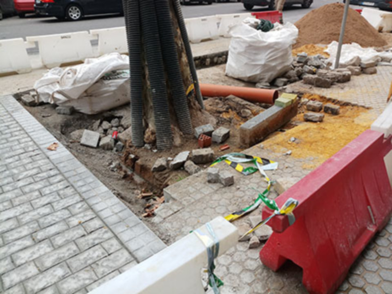 Trabajos de construcción en una calle con bloques de hormigón y materiales de construcción.