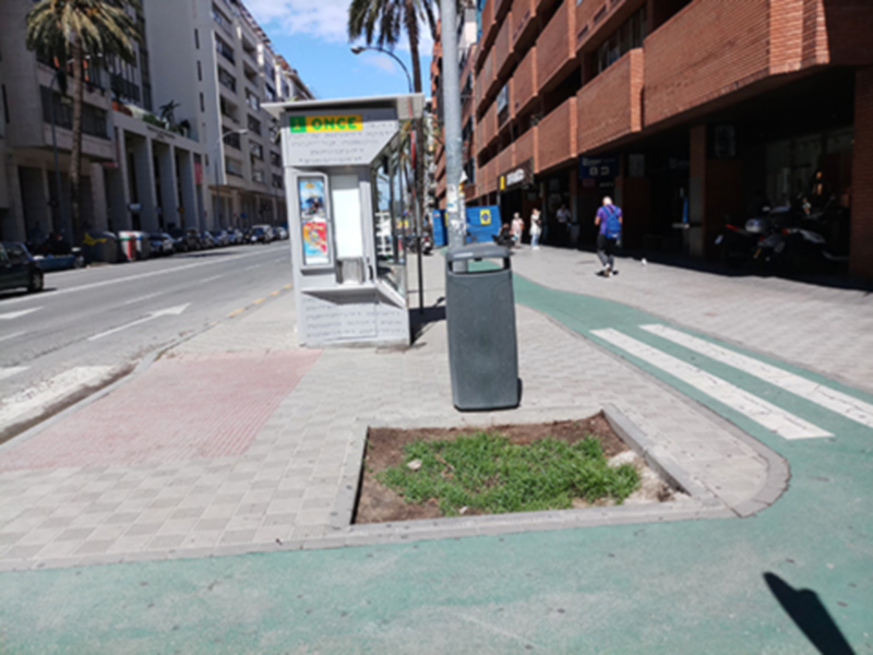 Una calle con edificios, un paraguas y una señal de tráfico.