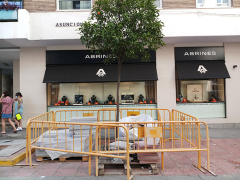 Tienda Abhines con barreras de seguridad y construcción en la entrada.