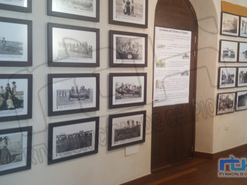 Una sala de exposiciones con fotografías enmarcadas y un cartel informativo.