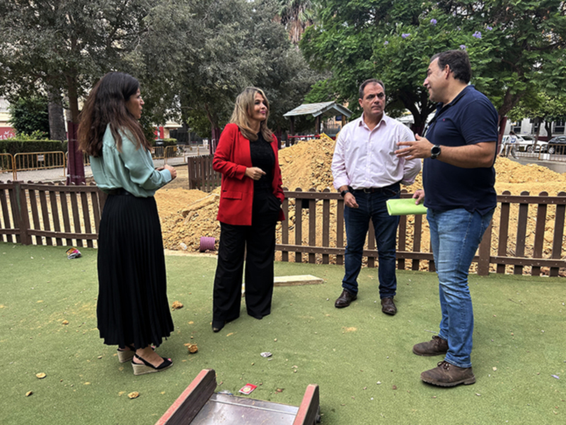 Personas discutiendo al aire libre en un espacio verde rodeado de árboles.