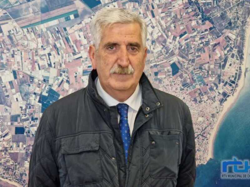 Retrato de hombre con camisa y chaqueta, fondo con mapa aéreo de Chipiona