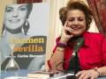 Carmen Sevilla posa con un libro de Carlos Harvey, sosteniendo una copa y sonriendo.