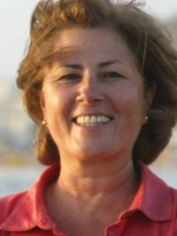 Retrato de mujer sonriente con camisa roja al aire libre.