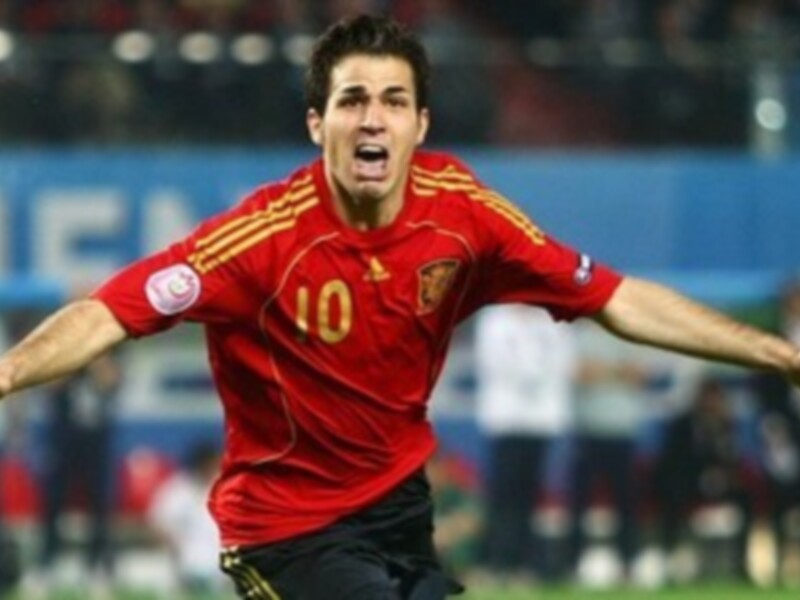 Un jugador de fútbol con una camiseta roja y amarilla, marcada con el número 10, celebrando un gol en un partido de fútbol.