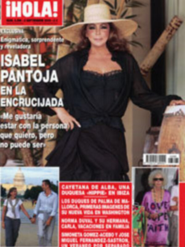 Isabel Pantoja en la portada de ¡HOLA!, con un sombrero y vestida elegante, posando frente a una casa.