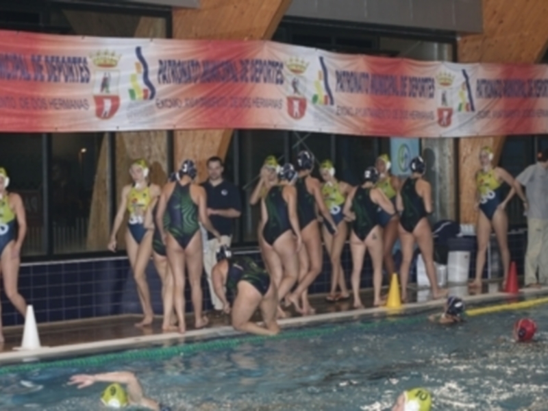 Equipo femenino de natación posando en la línea de salida del evento.