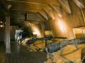 Interior de una nave antigua con armas y madera.