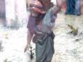 Figura de un hombre cargando una cesta de frutas en un escenario de pesebre.