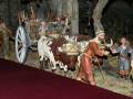 Figuras de una representación de la natividad con animales y personajes en un entorno escénico.