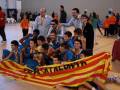 Estudiantes celebrando con una bandera de Cataluña en un gimnasio.