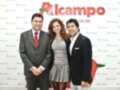 Dos hombres y una mujer posan frente a un fondo con el logo de Alcampo.