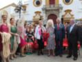 Celebración en Sevilla, España. Personas vestidas con trajes típicos españoles posan frente a un edificio histórico.