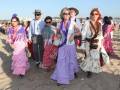 Una familia en trajes típicos de la Feria de Abril en Sevilla, con vestidos coloridos y sombreros.