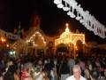 Festivities in a town square with a decorated church and people celebrating.