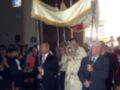 Celebración religiosa en una iglesia, con personas sosteniendo una bandera procesional.
