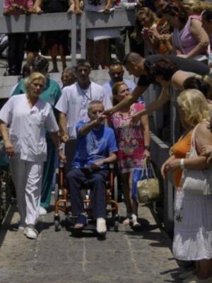 Ortega Cano dado de alta mucho más delgado, pelo corto canoso, agradecido y con un rosario 