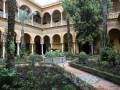 Elegante patio interior con arcos y jardín bien cuidado, típico de la arquitectura andaluza.