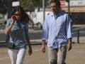 Una pareja camina por una calle con bicicletas y un poste de luz en el fondo.