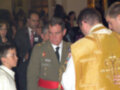 Celebración religiosa con autoridades militares y sacerdotes en un interior iluminado.