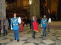 Guardias militares en uniforme azul y rojo, con insignias doradas, marchando dentro de una catedral.