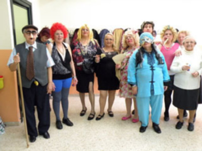 Una familia conmemorativa en una imagen festiva, incluyendo a un hombre vestido como un payaso y varias personas disfrazadas de personajes cómicos, posando juntos en un entorno interior.