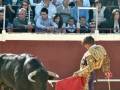 Un torero en traje de luces realiza una faena en el ruedo durante una corrida de toros.