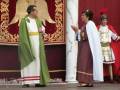 Actores en trajes romanos en escenario, representando una escena histórica.