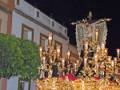 Procesión religiosa con imagen de la Virgen y Cristo en una carroza ornada, celebrada en la noche.
