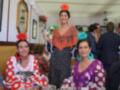 Personas vestidas con trajes típicos españoles en un ambiente festivo, posiblemente durante el Día de la Raza en España.