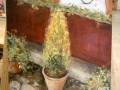 Pintura al óleo de un jardín con macetas y plantas en un soporte de arte