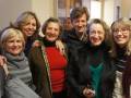 Un grupo de personas sonriendo y posando para una foto en un entorno interno, posiblemente en un centro de salud o centro de atención a la salud.