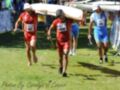 Canoistas corriendo con sus canoes en la competencia.
