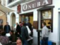 People enjoying their meals outside a restaurant named 'ONUBA'.