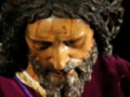 Representación escultórica de Jesús con barba y cabello rizado, vestido de luto con una corona de espinas y una túnica morada.