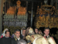 Una procesión religiosa en una iglesia con imágenes de la Virgen y estatuas religiosas.